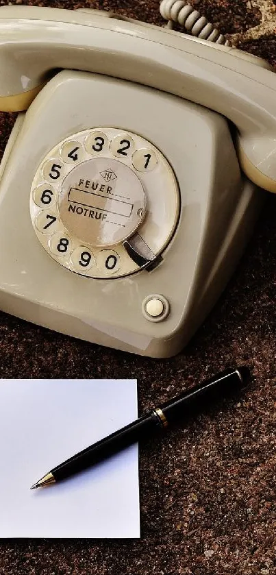 Vintage rotary phone on brown brick background with pen and notepad.