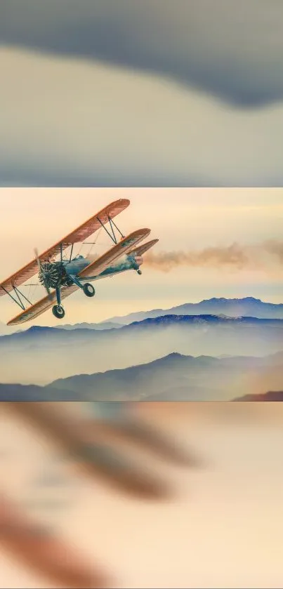 Vintage biplane flying over misty mountains at sunrise.