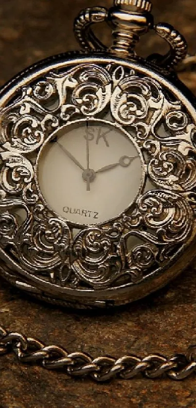 Vintage pocket watch with chain on a rustic brown surface.