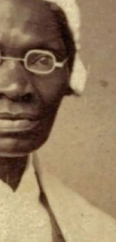 Sepia-toned portrait of a historical figure with glasses and a bonnet.