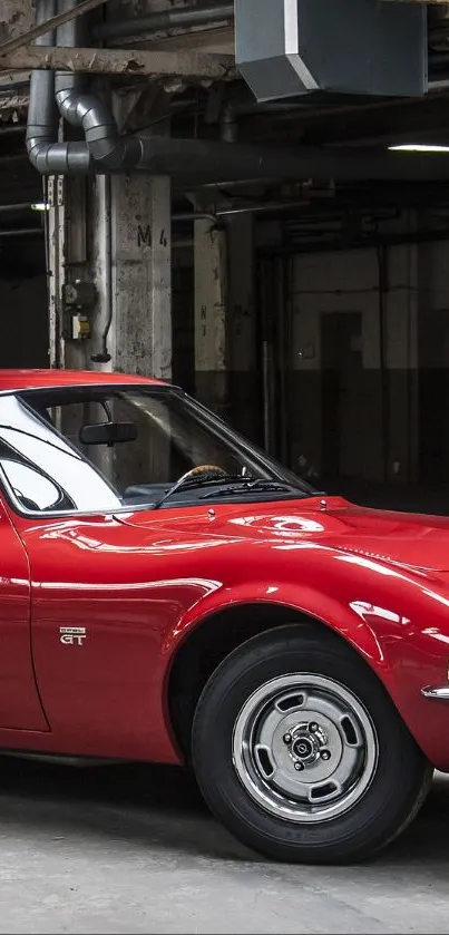 Vintage red car parked in an industrial warehouse setting, showcasing classic design.