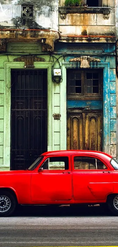 Vintage red car parked on an old street with rustic buildings.