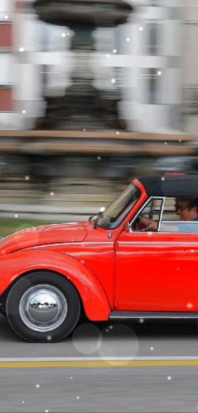 Red vintage car driving through a blurred city street.
