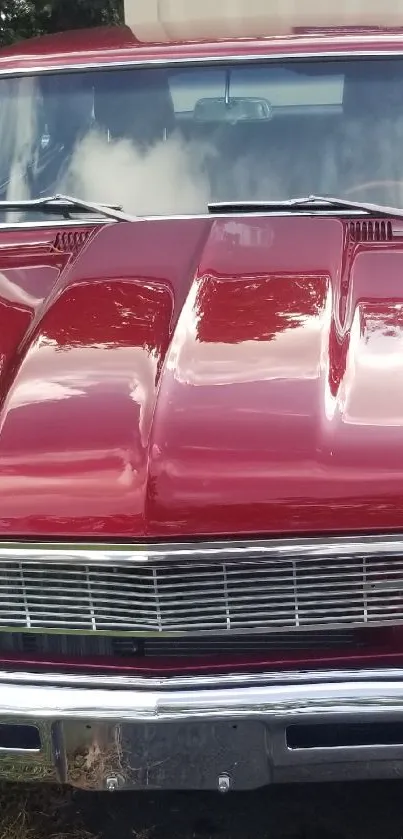 Front view of a vintage red classic car parked on a driveway.