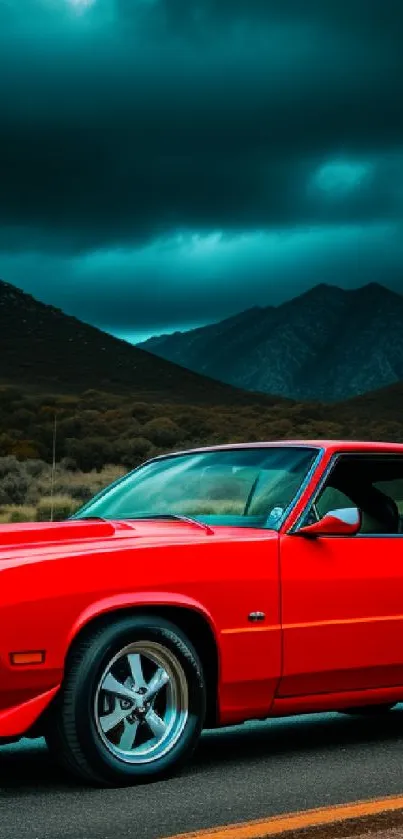 Vintage red muscle car on a road with mountains and stormy sky in background.