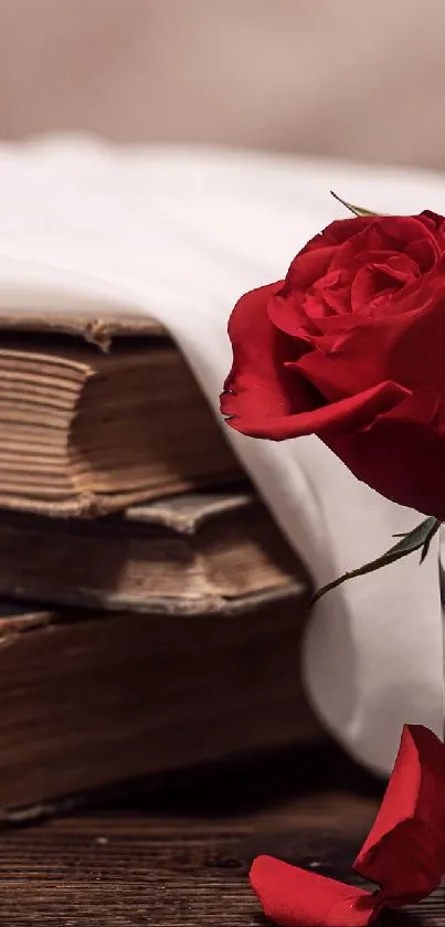 Red roses in a vase beside vintage books on a wooden table.