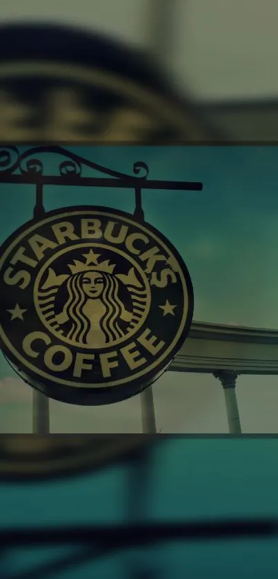 Vintage Starbucks Coffee sign against teal sky.