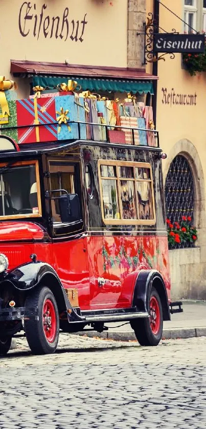 Vintage red car on cobblestone street with historic buildings.