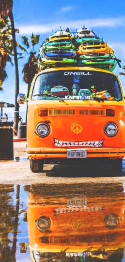 Orange van with surfboards by the beach, reflected in water.