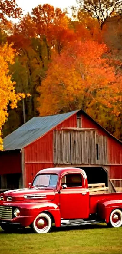 Classic red truck by a rustic barn with fall foliage.
