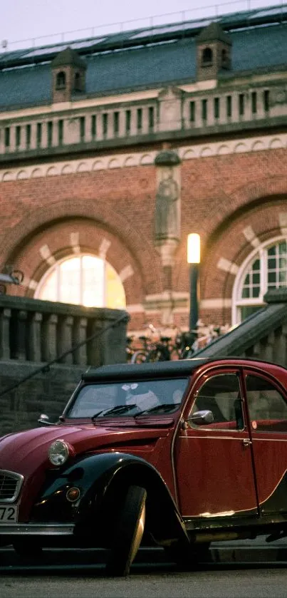 Vintage red car in urban setting with brick building backdrop.