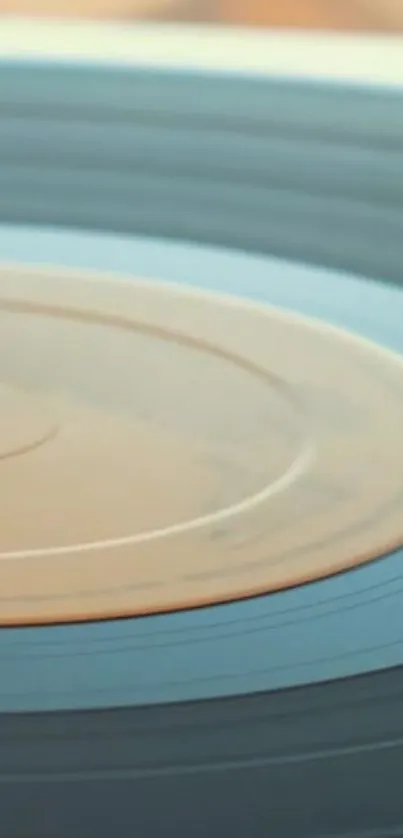 Close-up of a spinning vintage vinyl record with a blue-gray tone.