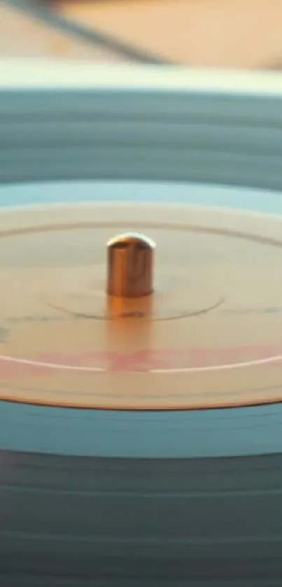 A close-up of a vinyl record spinning on a turntable with a light blue tint.