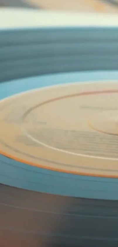 Close-up of a spinning blue vinyl record, vintage aesthetic for mobile wallpaper.