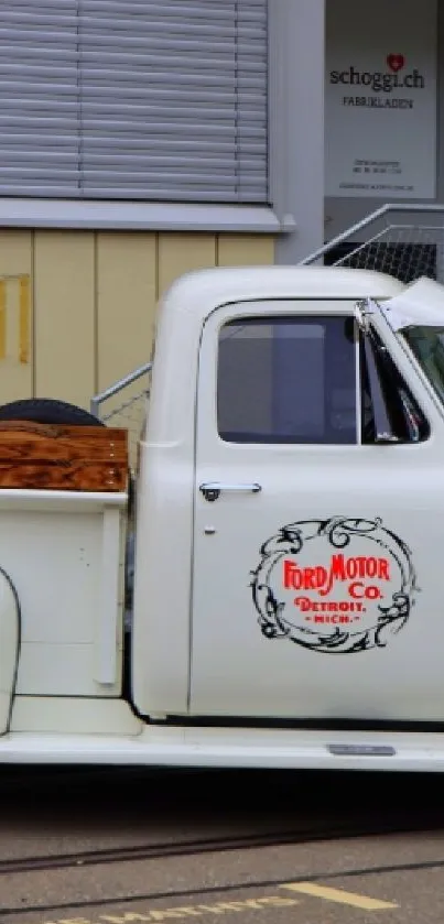 Vintage white truck parked in front of a building, showcasing classic design.