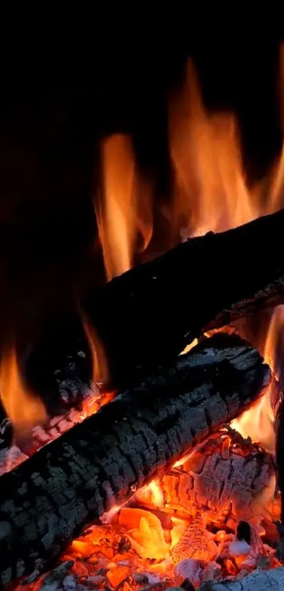 Mobile wallpaper featuring burning firewood with vibrant orange flames.