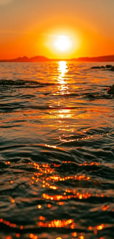 Vivid sunset reflects on ocean creating a tranquil scene.