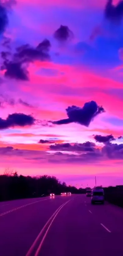 Vivid sunset with pink and purple sky over a road.