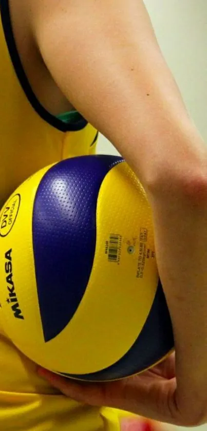 Volleyball player holding yellow and purple ball.