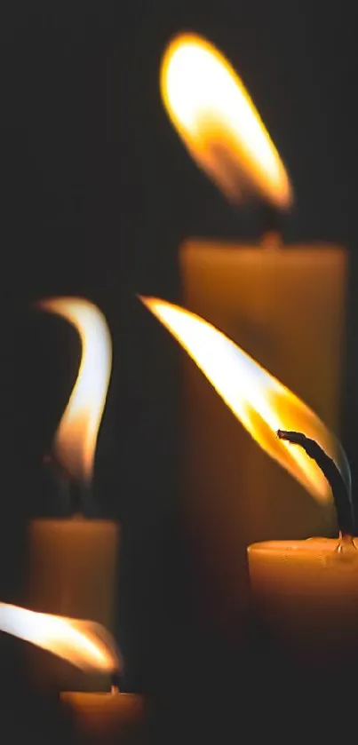 Warm candle flames in the dark creating a cozy atmosphere.