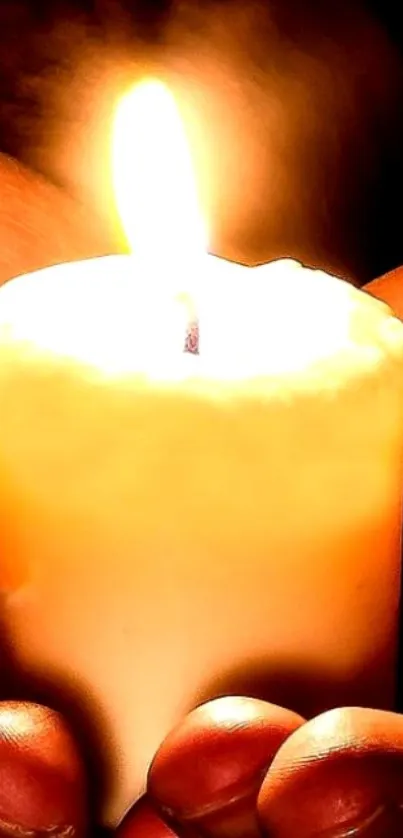 Hand-held glowing candle emitting serene and warm light.