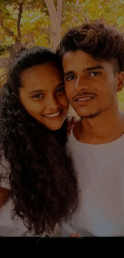 Smiling couple in a warm outdoor setting.