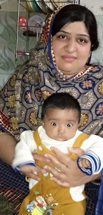 Mother holding baby in colorful attire, warm family scene.