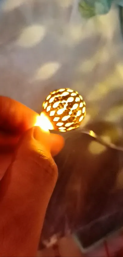 Hand holding a glowing orb with warm light against a soft background.