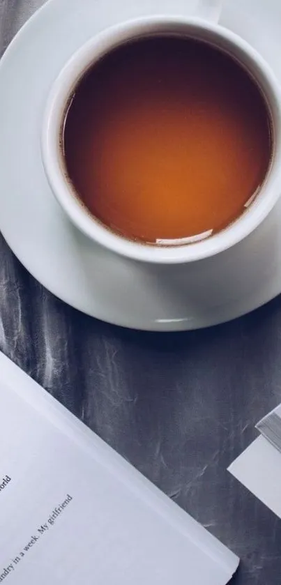 Cup of tea with open book resting beside it.