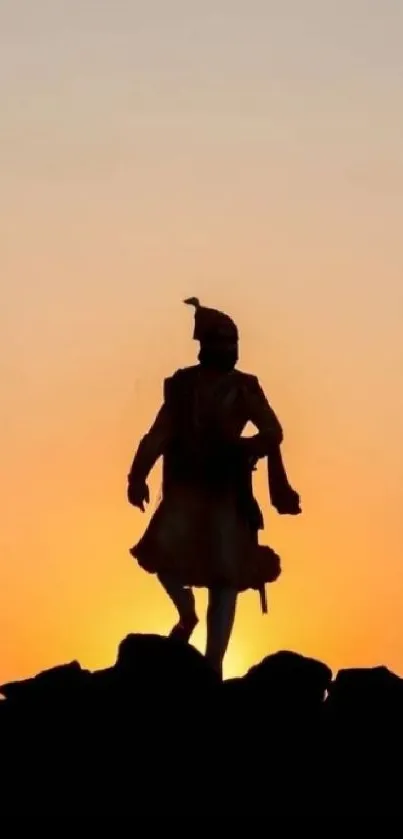 Warrior silhouette in front of vibrant orange sunset.