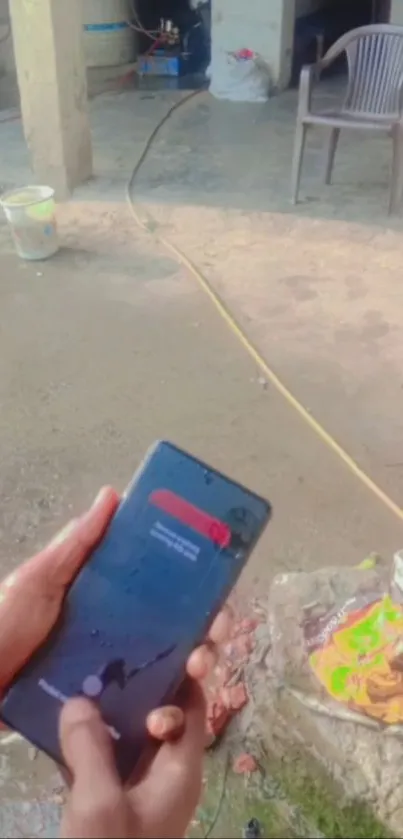 Hands holding a water-resistant smartphone outdoors.