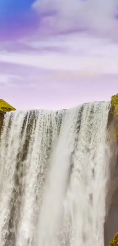 Soothing waterfall under a rainbow with lush green surroundings.