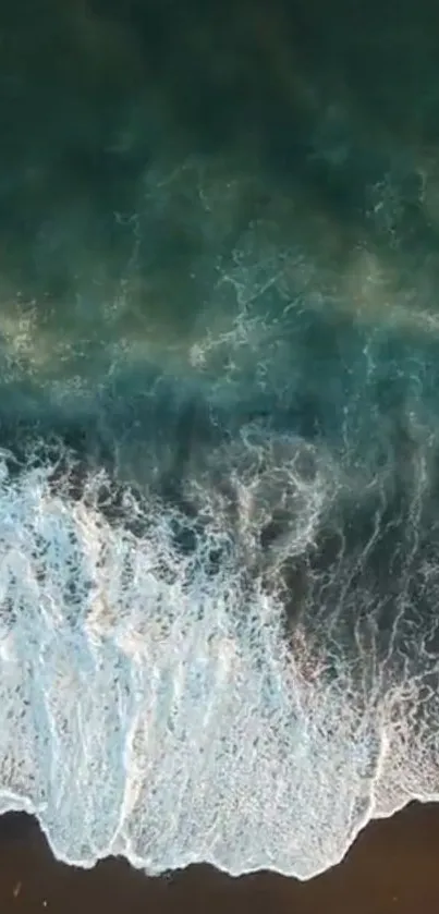 Aerial view of turquoise ocean waves crashing onto a sandy beach.