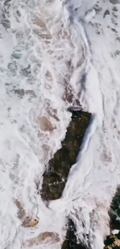 Aerial view of waves crashing over rocks.