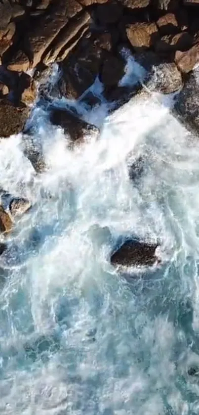 Aerial view of ocean waves crashing on rugged rocks.