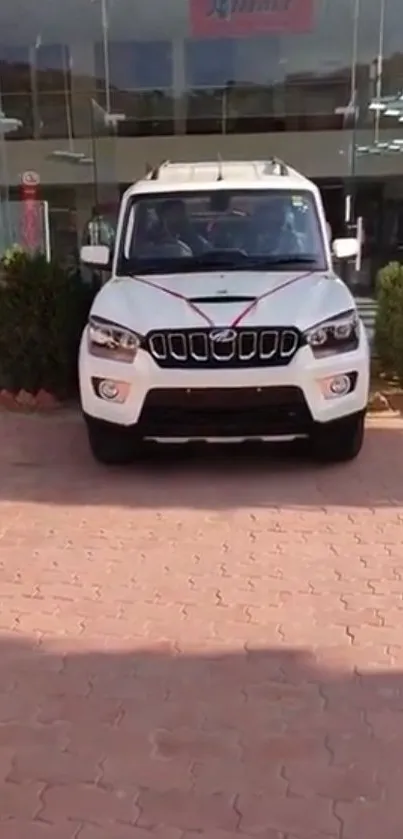 Front view of a white SUV parked in a showroom driveway.