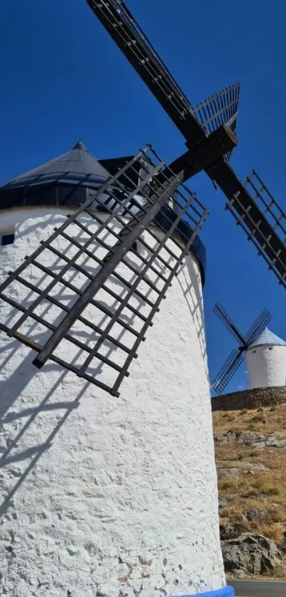 Traditional white windmills under blue sky.