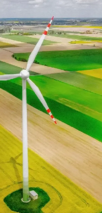 A wind turbine stands tall among vibrant green fields.