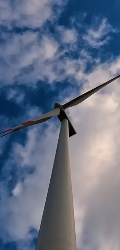 Wind turbine set against a sky with clouds.