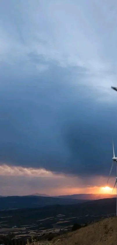 Wind turbines against a colorful sunset sky, symbolizing renewable energy.