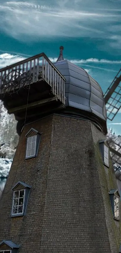 Historic windmill by a winter lake with sky blue background.