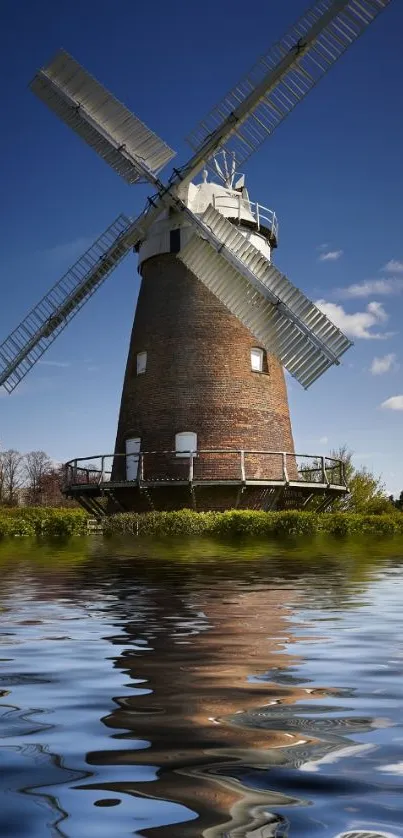 Windmill with water reflection under blue sky wallpaper.