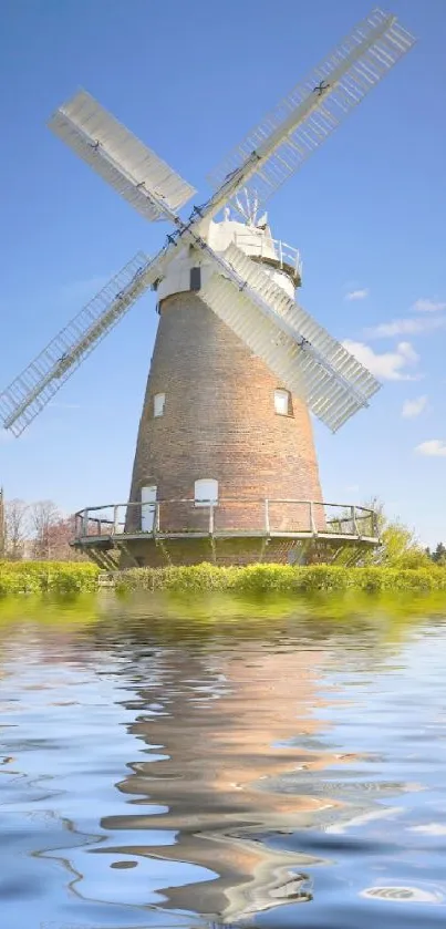 Windmill with water reflections under a blue sky mobile wallpaper.