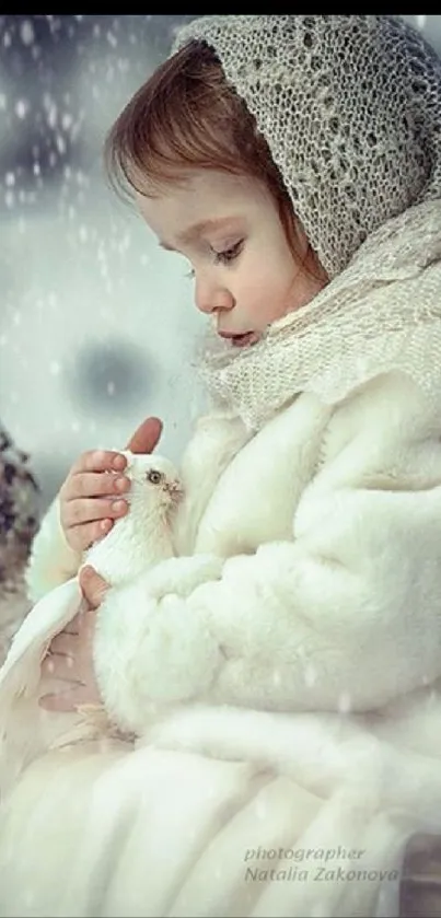 Child in winter attire holding a dove in snow.