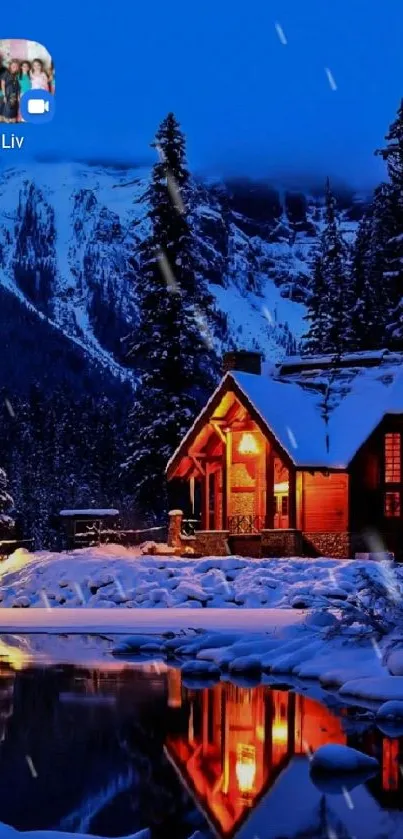 Winter cabin by snowy lake at night.