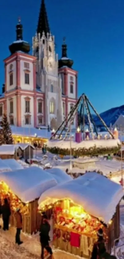 Snowy winter market by illuminated cathedral at dusk.