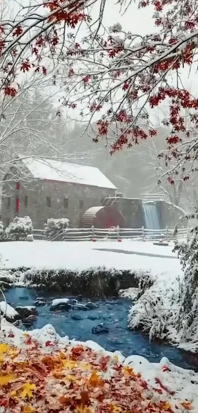 Snowy mill by a stream surrounded by fall leaves and trees.