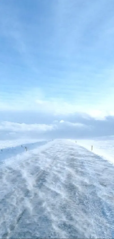 Serene winter road under a bright blue sky, perfect for mobile wallpaper.