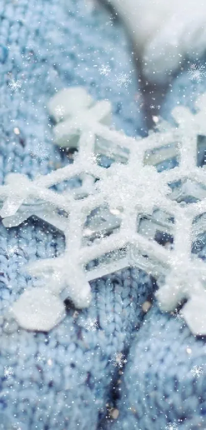 Snowflake held in cozy blue gloves on a winter background.