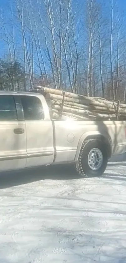 Pickup truck hauling timber on a snowy road in a winter forest.